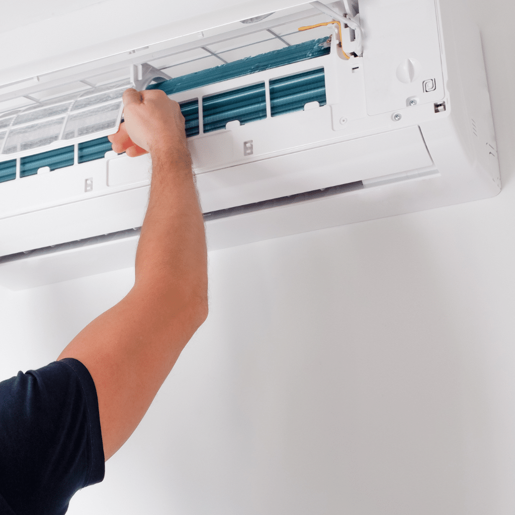 Technician replacing a failed AC capacitor in a Midwest City residential home during a summer heatwave emergency