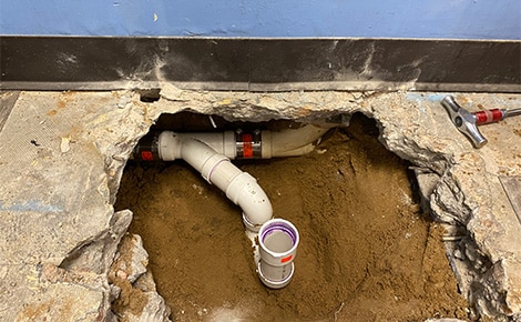 Certified plumber inspecting older pipes in a Nichols Hills, OK home with advanced diagnostic tools