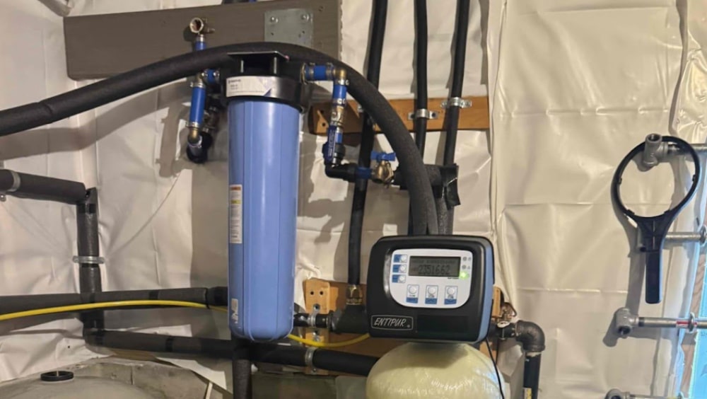Technician from Anderson Plumbing Heat and Air installing an advanced water filtration system in a Midwest City, OK home