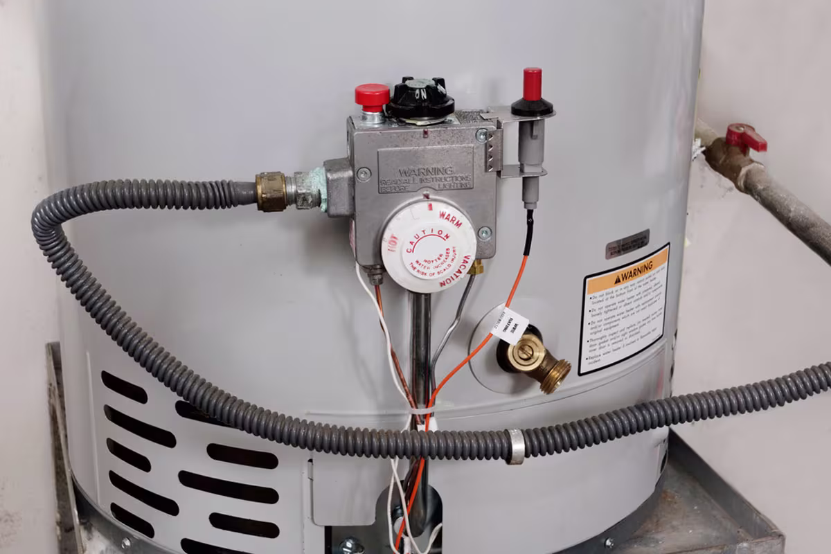 Technician installing a new water heater in a Piedmont, OK residential laundry room with updated plumbing