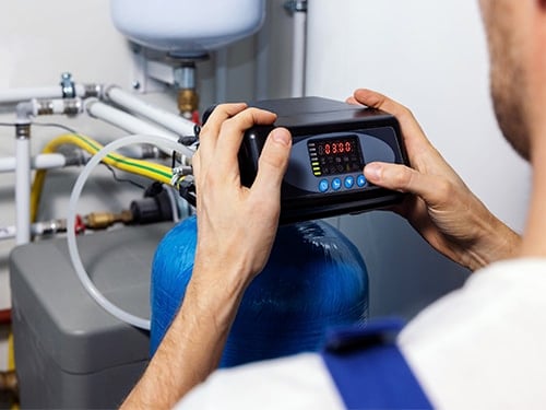 Certified plumber inspecting older pipes in a Nichols Hills, OK home with advanced diagnostic tools