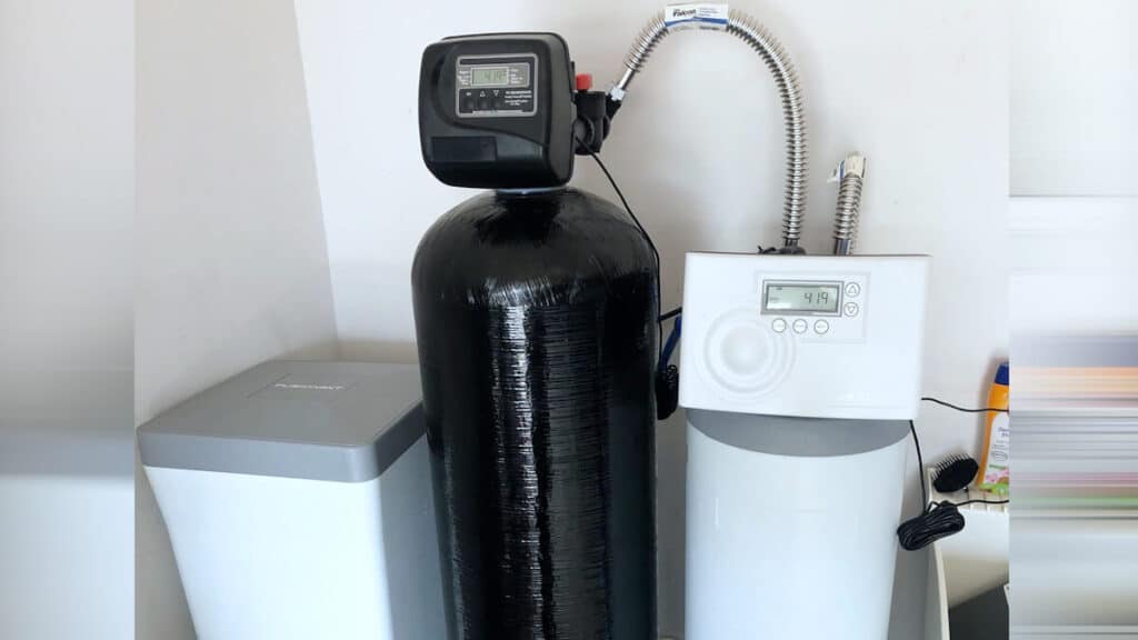 Technician completing top-rated water softener installation in a Piedmont, OK family kitchen