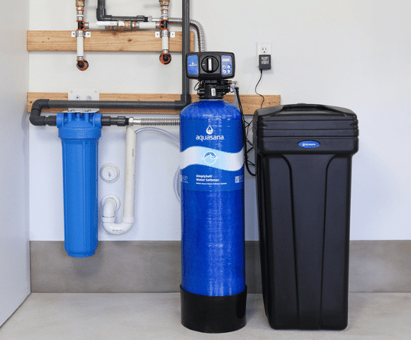Professional installing a new water softener in a Norman, OK home utility room for a local family