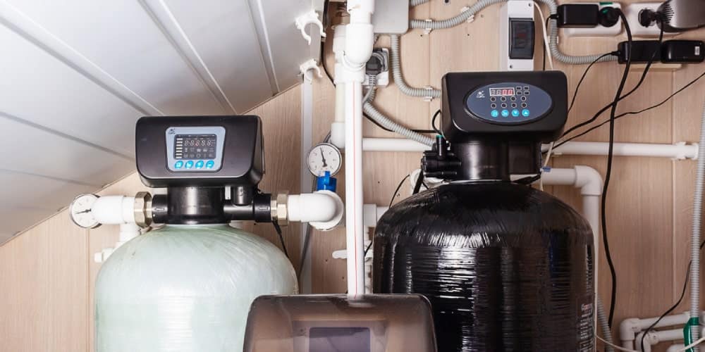 Technician carefully installing a water softener system in a modern Edmond, OK laundry room for a local family