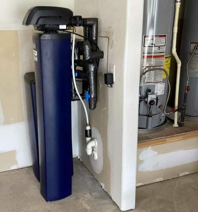 Expert installing advanced water softener in luxury Nichols Hills, OK home, demonstrating precise technique