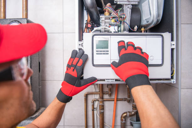 Furnace Repair in Norman, OK as a technician checks burner operation inside a residential heating cabinet