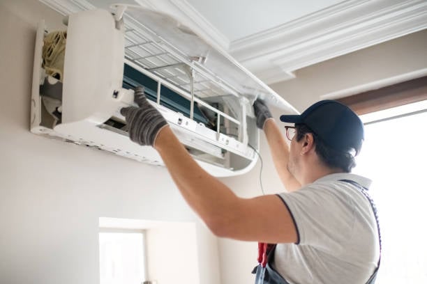 Technician completing HVAC installation adjustments in an Oklahoma City, OK attic with airflow testing equipment