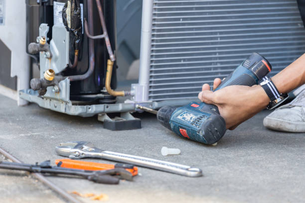 HVAC Installation in Moore, OK technician setting a new condenser pad beside a brick home