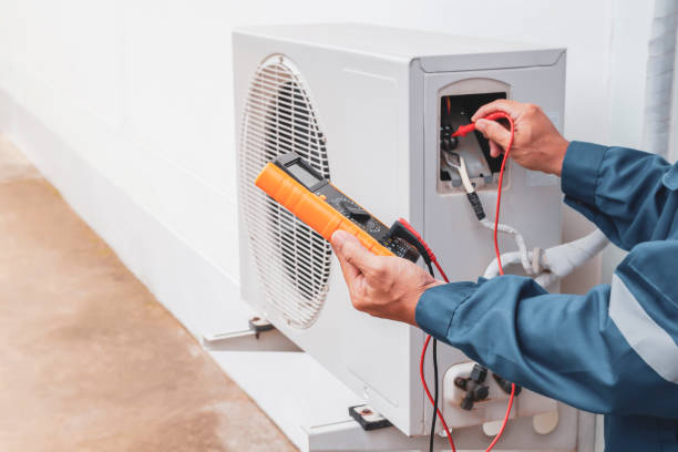 Technician completing HVAC installation testing in a Norman, OK home while checking return airflow