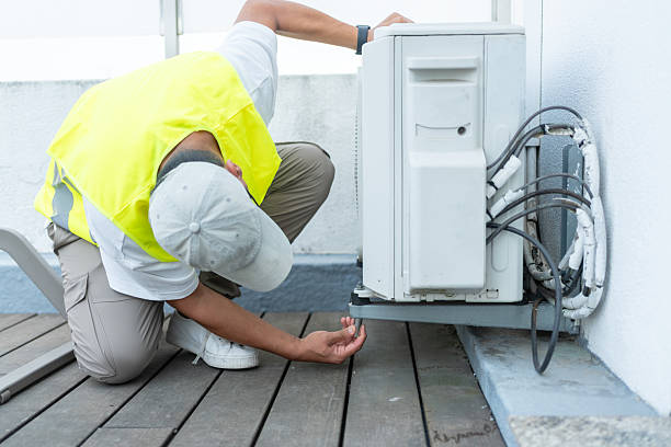 HVAC Repair in Moore, OK as a technician tests an outdoor condenser beside a brick home