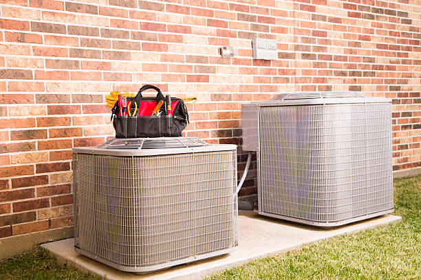 HVAC Repair in Norman, OK as a technician checks refrigerant readings outside a home