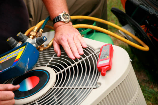 HVAC Repair in Yukon, OK as a technician checks refrigerant readings beside an outdoor unit