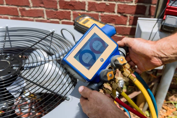 HVAC Repair in Edmond, OK as a technician inspects an indoor air handler panel